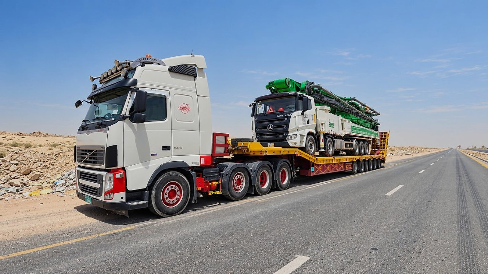 APEX MAKERS transporting heavy equipment on a low-loader